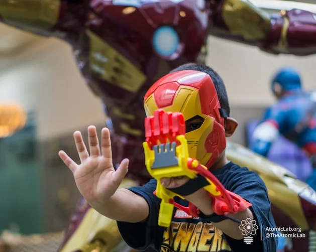 Un niño muestra su prótesis 3D inspirada en Iron Man junto a una figura del personaje